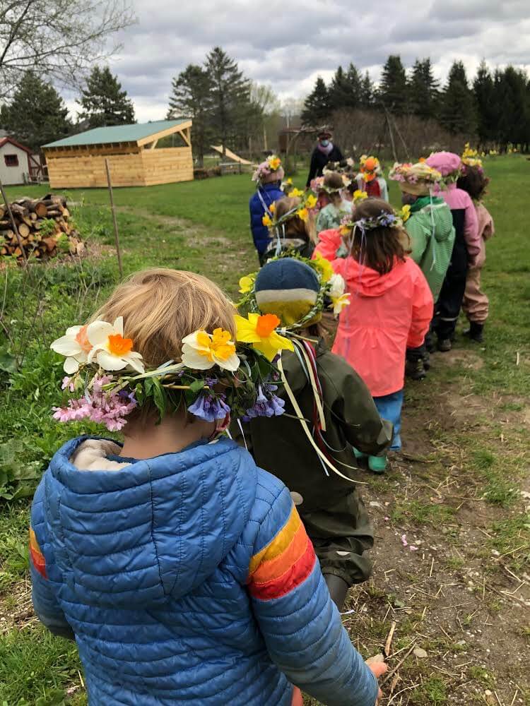 Children from the Pumpkin Patch kindergarten head out to the Maypole wearing flower crowns made that morning.